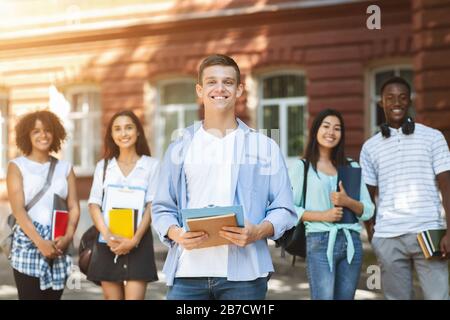 Concept du responsable étudiant. Beau Teen Guy posant à l'extérieur du campus de l'Université Banque D'Images