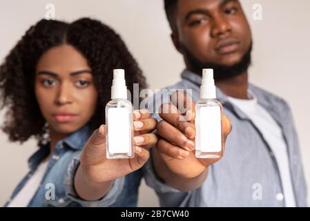 Vaporisateurs désinfectants dans les mains de jeunes Afro-américains, Mockup Banque D'Images