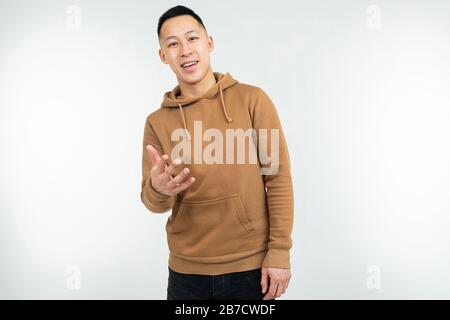 homme asiatique confiant dans le hoodie brun isolé sur fond blanc Banque D'Images