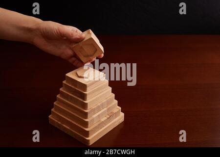 Jouet en bois de hêtre. Travail manuel sur la machine cnc. Pyramide avec formes géométriques. Développement et éducation parentale et divertissement des parents. Banque D'Images