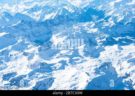 Panorama aérien alpin unique. Blue Planet Earth vue aérienne haute altitude des Alpes d'Europe centrale enneigées, vue depuis une cabine d'avion. E Banque D'Images