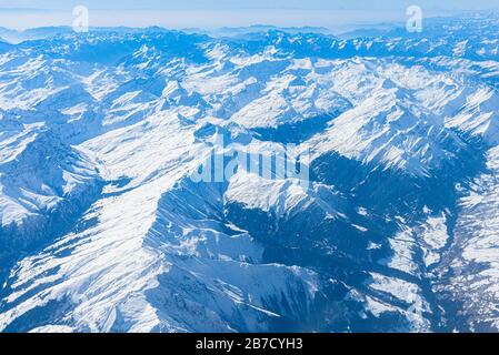 Panorama aérien alpin unique. Blue Planet Earth vue aérienne haute altitude des Alpes italiennes européennes enneigées, vue depuis une cabine d'avion. E Banque D'Images