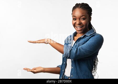 Femme en Braces Holding invisible Object Standing, White Background, Mockup Banque D'Images