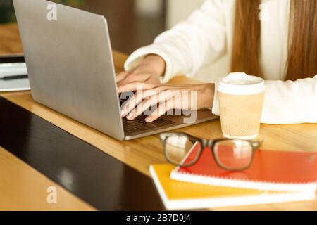 Fille travaille. Verres, carnets et café sur la table Banque D'Images