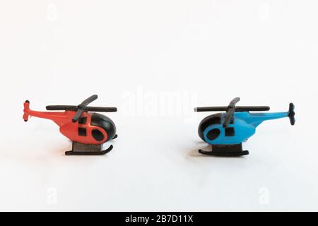 Petits jouets d'hélicoptère colorés isolés sur un fond blanc - voyage aérien par concept d'hélicoptère. Banque D'Images
