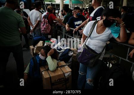 Manille, Philippines. 15 mars 2020. Les gens affluent vers un terminal de bus à Cubao, Quezon City pour quitter la capitale vendredi, 13 mars 2020 à la suite d'une annonce faite par le président Rodrigo Duterte jeudi soir d'un verrouillage imminent de 30 jours du métro Manille du 15 mars au 14 avril pour contenir la propagation du coronavirus (#COVID19) dans le pays. (Photo Larry Monserate Piojo/Sipa Usa) Crédit: Sipa Usa/Alay Live News Banque D'Images