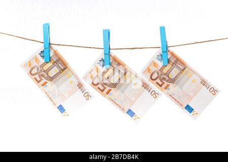 Les billets en euros sont fixés avec des pinces à linge bleu à une corde sur un fond blanc Banque D'Images