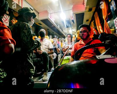 Philippines. 15 mars 2020. (3/15/2020) les policiers ont interrompu et embarqué un bus public entièrement rempli pour l'inspection des symptômes du Covid-19 au point de contrôle de quarantaine communautaire de la sortie Susanna, dans la RCN. La police leur a également rappelé que les sièges doivent être séparés d'un siège pour prévenir l'infection, y compris l'importance d'un masque facial chaque fois qu'ils sont en public. A partir d'aujourd'hui, divers points de contrôle sont en place dans les entrées et sorties principales et stratégiques du métro Manille, des mesures comme celles-ci sont prises pour empêcher la propagation du Covid-19 en faisant contrôler le mouvement et le voyage des personnes. Crédit: Sipa Usa/Alay Live News Banque D'Images