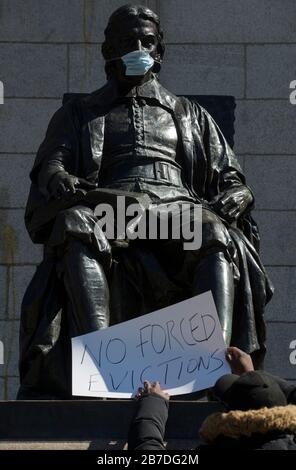 Massachusetts, États-Unis. 14 mars 2020. Sculpture du fondateur de l’Université Harvard John Harvard dans le Harvard Yard, au centre du campus de Harvard, le visage de Harvard a été recouvert d’un masque facial. En réaction aux préoccupations de Coronavirus à l'Université Harvard a annoncé qu'à partir du 23 mars 2020, toutes les classes seront éloignées ou en ligne. On a demandé aux étudiants vivant dans des résidences universitaires de partir avant le 22 mars 2020. Après les plaintes des étudiants Harvard fait des logements pour les étudiants incapables de retourner à leur maison. Crédit: Chuck Nacke/Alay Live News Banque D'Images