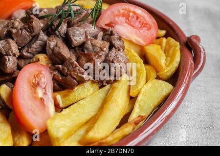 Plat traditionnel de l'île de Madère, appelé 'Picado' ou 'Picadinho', préparé avec du boeuf coupé en petits cubes, frites tranches de tomates et d'ail. Banque D'Images