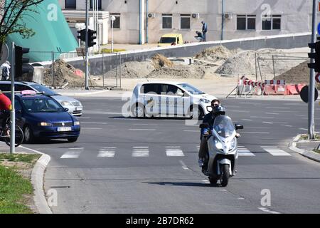 Motocyclistes et voitures dans la rue.en arrière-plan d'une pile de sable devant un bâtiment en construction Banque D'Images