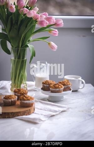 Muffins aux pommes de carotte sur un stand de gâteau blanc Banque D'Images