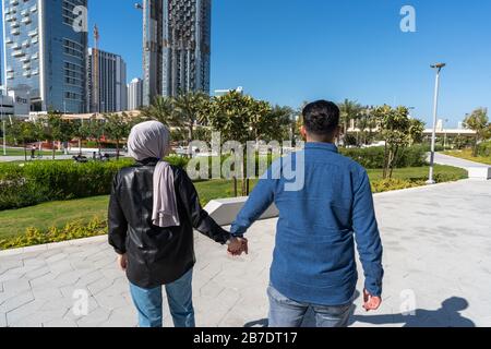 Un couple musulman aime marcher dehors dans un parc tout en tenant les mains Banque D'Images