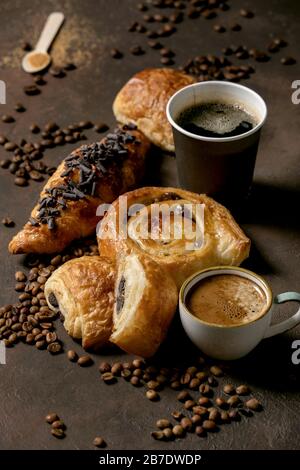 Variété de pâtes à base de pâte feuilletée et de pains au chocolat, croissant avec différentes tasses de papier et de céramique, grains de café, recyclé W. Banque D'Images