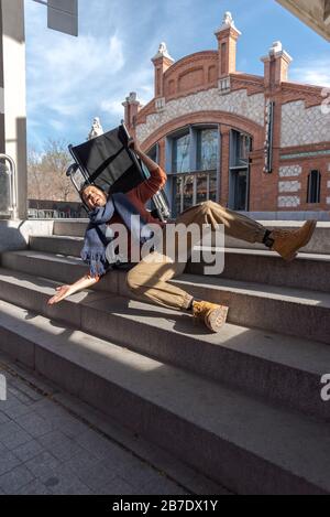 Handicapés Latino jeune homme dans un fauteuil roulant tombe dans certains escaliers, il ne peut pas descendre avec la chaise dans la rue Banque D'Images