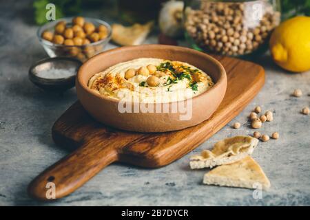 Houmous et pain pita. Grand bol de houmous maison garni de pois chiches, de poivron rouge, de persil et d'huile d'olive, de nourriture du milieu-est, espace de copie Banque D'Images