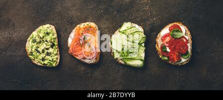 Variété de sandwichs pour le petit-déjeuner, en-cas, hors-d'œuvre - purée d'avocat, mozzarella, tomates, basilic, fromage à la crème, saumon fumé, oignon rouge, concombre Banque D'Images