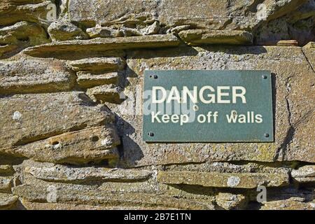 Danger laissez les murs signer sur les anciens murs de l'abbaye de Balmerino, Fife, Écosse Banque D'Images