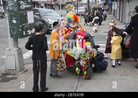 La communauté juive orthodoxe de Borough Park Brooklyn célèbre les vacances festives de Purim en portant des costumes, en donnant aux pauvres, en mangeant des aliments savoureux et en général en ayant un bon moment. Personnes sur la 13ème Avenue. Purim est célébré chaque année le 14 du mois hébreu d'Adar . Il commémore le salut du peuple juif de l’ancien empire persan du complot de Haman « détruire, tuer et annihiler tous les Juifs, jeunes et vieux, nourrissons et femmes, en un seul jour », tel qu’enregistré dans la Megillah (livre d’Esther). Banque D'Images