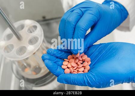 Pharmacien en gants médicaux testant de nouvelles pilules de médecine dans un laboratoire pharmaceutique. Concept de l'industrie pharmaceutique Banque D'Images