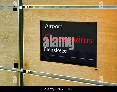 Écran d'affichage électronique dans un terminal d'aéroport avec message "porte fermée" et "Coronavirus" Banque D'Images