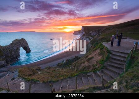 Durdle Door, Lullworth, Dorset, Royaume-Uni. 15 mars 2020. Météo britannique. Les spectateurs qui regardaient le spectaculaire coucher de soleil à Durdle Door sur la côte jurassique Dorset près de Lullworth, alors que le nuage disparaît à mesure que la haute pression s'accumule du Sud-Ouest. Crédit Photo : Graham Hunt/Alay Live News Banque D'Images