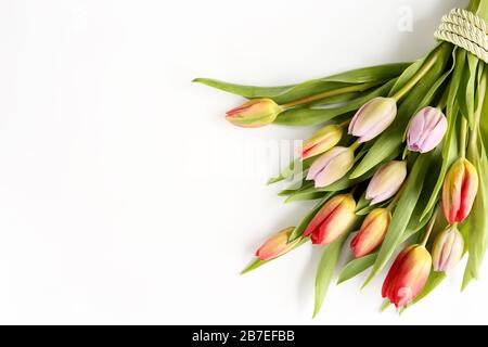 Bouquet de fleurs de printemps de tulipes multicolores avec ruban vert pour Pâques, célébration, félicitations, salutations, fête des mères Banque D'Images