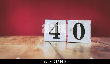 Numéro 40 sur une table en bois vintage et un fond marron foncé - style rétro blocs blancs Banque D'Images