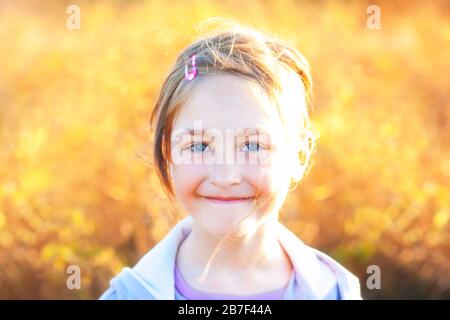 Portrait d'une fille d'été sur un pré d'arrière-plan jaune flou au coucher du soleil. Profondeur de champ peu profonde. SDF. Banque D'Images