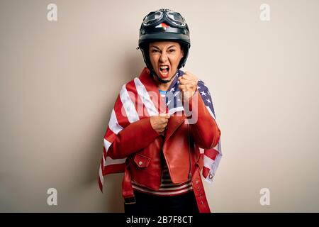 Une automobiliste d'âge moyen portant un casque de moto et un drapeau des États-unis s'est énervé et frustré de crier avec colère, folle et affliger avec des rais Banque D'Images