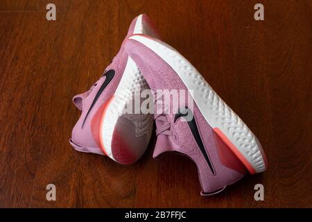 Paire de chaussures de course à pied roses Nike Epic React 2 sur parquet Banque D'Images
