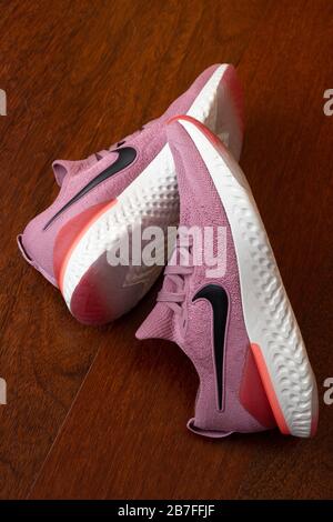 Paire de chaussures de course à pied roses Nike Epic React 2 sur parquet Banque D'Images