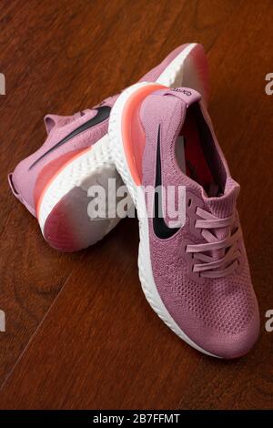Paire de chaussures de course à pied roses Nike Epic React 2 sur parquet Banque D'Images