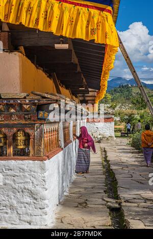Une femme prie un temple bouddhiste au Bhoutan par une journée ensoleillée Banque D'Images
