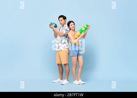 Jeune couple asiatique en été ensembles avec canons à eau en studio fond bleu pour le festival Songkran en Thaïlande et en Asie du Sud-est Banque D'Images