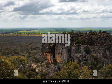 Vues de la montagne de Hollow avec des champs de canola jaunes au loin. Le parc national des Grampions, Victoria, Australie. Banque D'Images