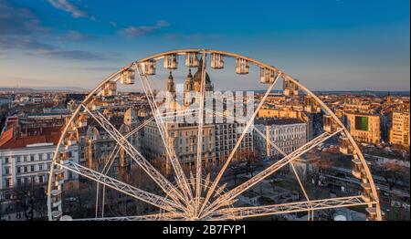 Budapest, Hongrie - vue panoramique aérienne de la roue ferris sur la place Elisabeth (Erzsebet ter) au coucher du soleil avec la basilique Saint-Étienne et le ciel bleu à Banque D'Images