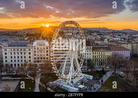 Budapest, Hongrie - vue aérienne de la célèbre roue ferris de Budapest avec le palais royal du château de Buda et un incroyable coucher de soleil en arrière-plan. La roue ha Banque D'Images