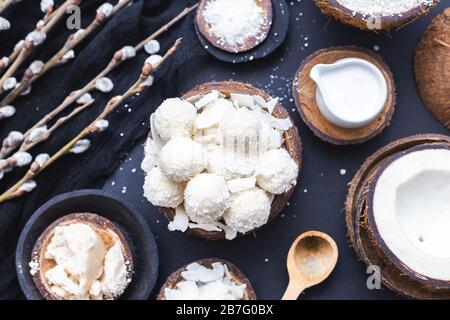 Bol de raffaello cru dans un bol en bois avec du lait de coco, des morceaux, du beurre et une cuillère en bois Banque D'Images