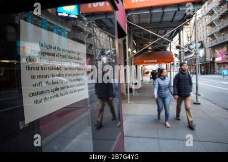 New York, États-Unis. 15 mars 2020. Les piétons passent par un restaurant fermé à New York, aux États-Unis, le 15 mars 2020. En raison de préoccupations concernant la propagation de COVID-19, de nombreux lieux publics de la ville ont été fermés par mesure de précaution. Crédit: Michael Nagle/Xinhua/Alay Live News Banque D'Images
