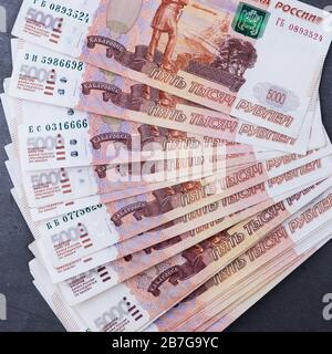 Pile de billets de l'argent russe de cinq mille roubles couché ventilateur sur une base de ciment gris Banque D'Images