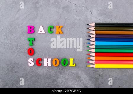 L'acheminement de fournitures scolaires sur un fond gris foncé. La vue du sommet. Retour à l'école. Mise à plat Banque D'Images