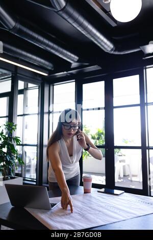 Femme architecte asiatique ayant un appel téléphonique d'affaires Banque D'Images