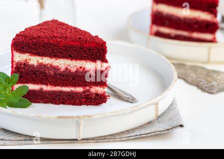 Gâteau velours rouge sur deux assiettes blanches, deux portions. Sur fond clair. Anniversaire, vacances, bonbons. Banque D'Images