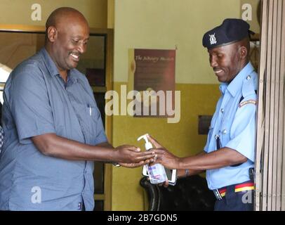 Nairobi. 16 mars 2020. Un policier offre de l'aseptisant à un passant à l'entrée du bâtiment de la Cour suprême à Nairobi, au Kenya, le 15 mars 2020. Le président kenyan Uhuru Kenyatta a annoncé des mesures rigoureuses pour aider à contenir la propagation du coronavirus mortel après deux nouveaux cas confirmés dimanche. L'Afrique subsaharienne a signalé plus de nouveaux cas de coronavirus (COVID-19) dimanche dans le contexte de contre-mesures plus fortes contre la pandémie. Crédit: Xinhua/Alay Live News Banque D'Images