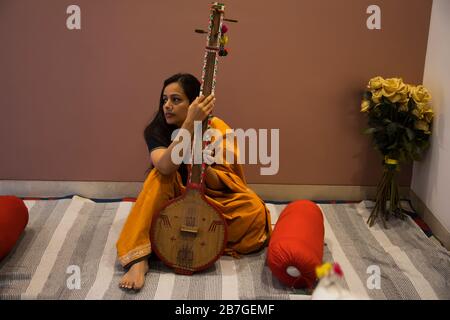 Femme jouant de la musique sur son tampura. Banque D'Images