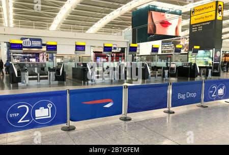 Les comptoirs d'enregistrement désertés du terminal 5 de l'aéroport d'Heathrow de Londres après que les horaires de vol ont été réduits par la société mère de British Airways IAG. Banque D'Images