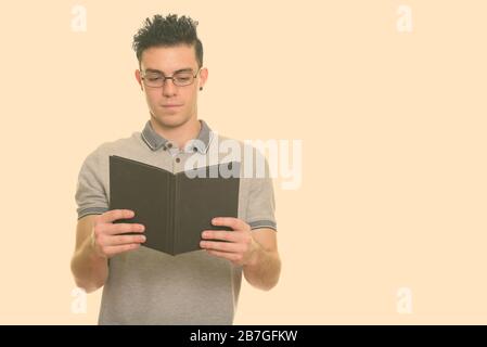 Studio shot of young man reading book Banque D'Images