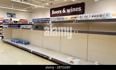 Les rayons presque vides de bière dans un supermarché à Ashford, dans le Kent, alors que les acheteurs achètent des fournitures au milieu de la pandémie de coronavirus. Banque D'Images