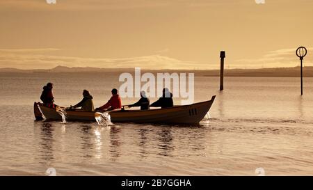 Portobello Beach, Édimbourg, Écosse, Royaume-Uni. 16 mars 2020. Les gens qui se calment et qui s'en acquittent avec leur routine normale. Activité matinale en bord de mer. Temps, soleil brumeux avec une température de 3 degrés après une nuit très froide, pluie attendue de l'ouest plus tard. Le Eastern Amateur Rowing Club est sorti pour l'exercice. Banque D'Images